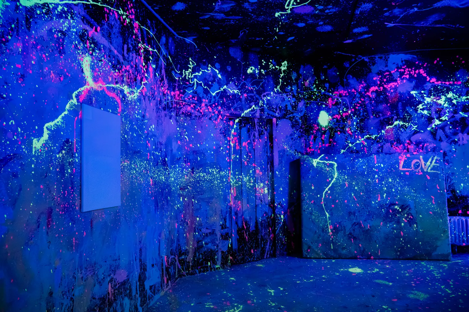 Neon Rage Room im Schwarzlicht mit leuchtenden Farbspritzern