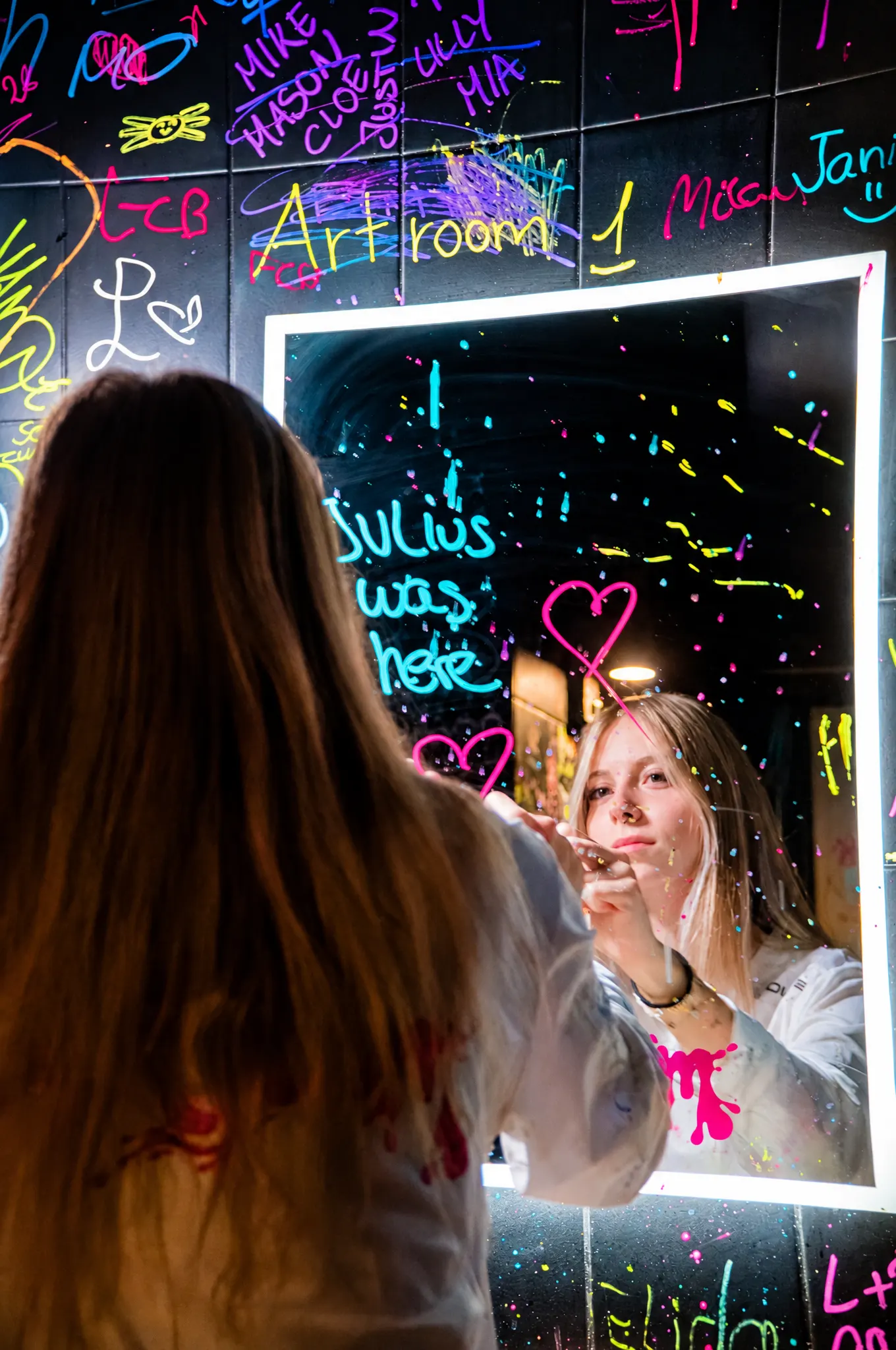 Gast schreibt mit Neonstift auf den Spiegel